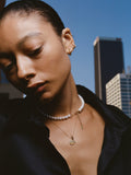 14kt Yellow Gold Disk and Toggle Necklace pictured on model.  City background.
