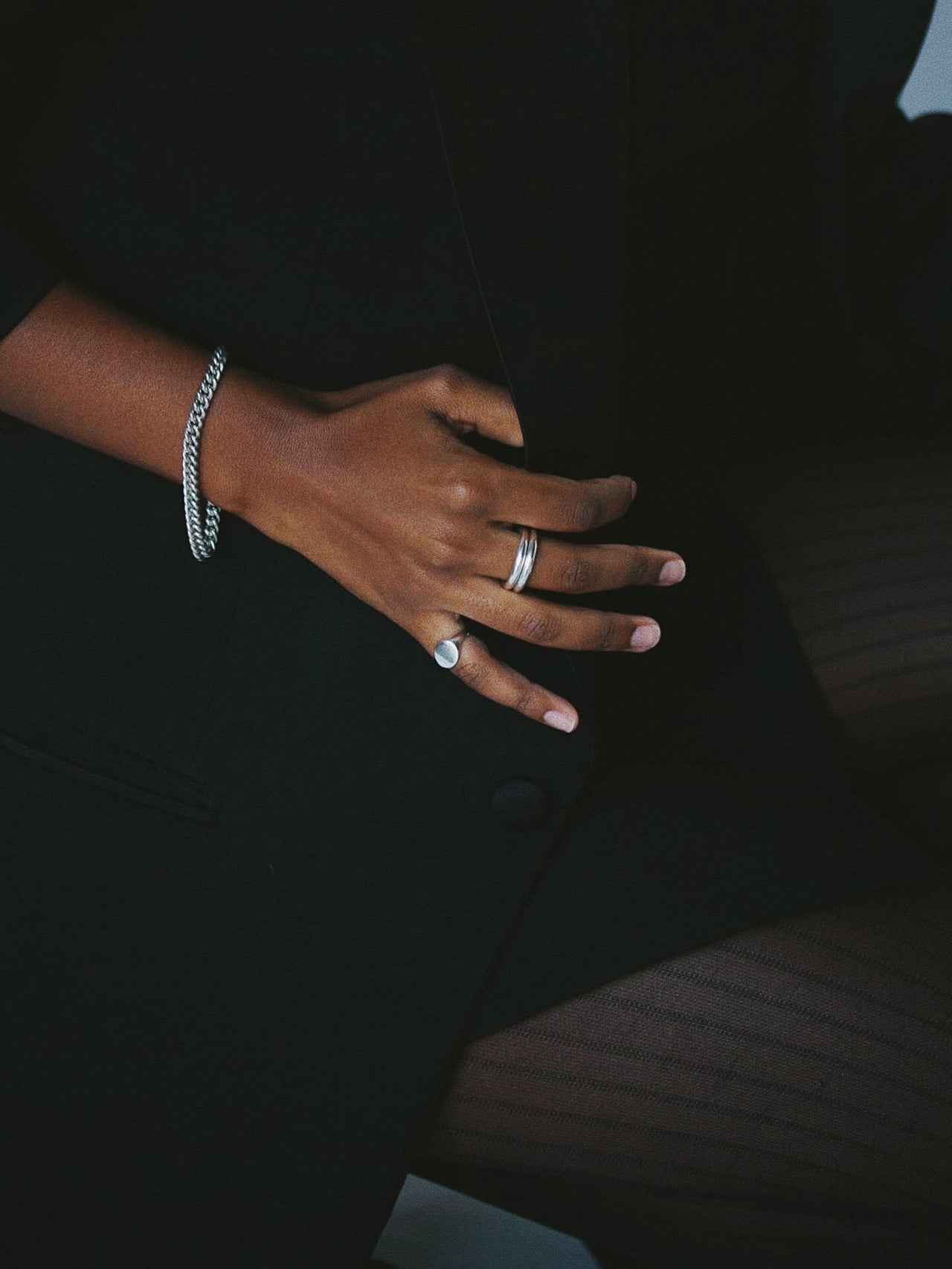 Petite Industrial Curb Chain Bracelet pictured in sterling silver on models wrist. Wearing all black for strong contrast. 