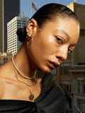 14kt Yellow Gold Rice Pearl Choker pictured on model. City scape background.