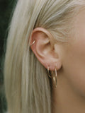 14Kt Yellow Gold Ultralight Infinity Hoops pictured worn in models second piercing.