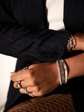 Sterling Silver Herringbone Chain Bracelet pictured styled on models wrist with other bracelet styles.