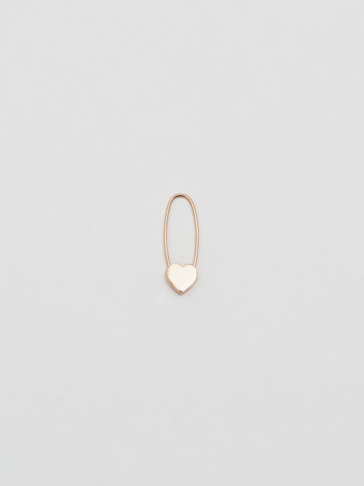 Rose Gold Heart Safety Pin pictured on grey background.