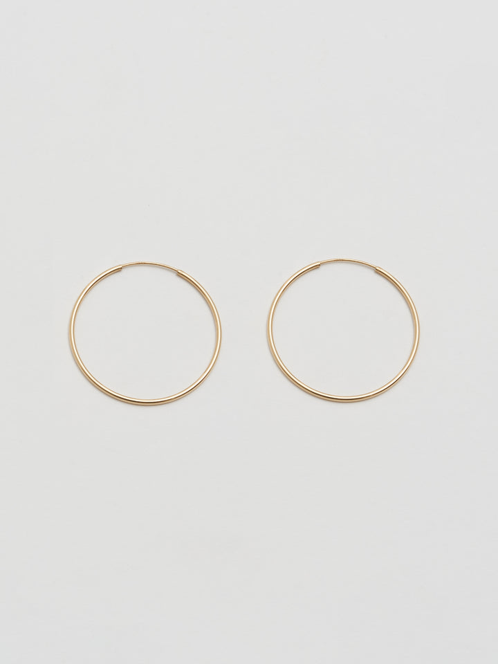 Product shot the Winona Hoops ( 14Kt Yellow Shiny Gold Hoops) Background: Grey paper 