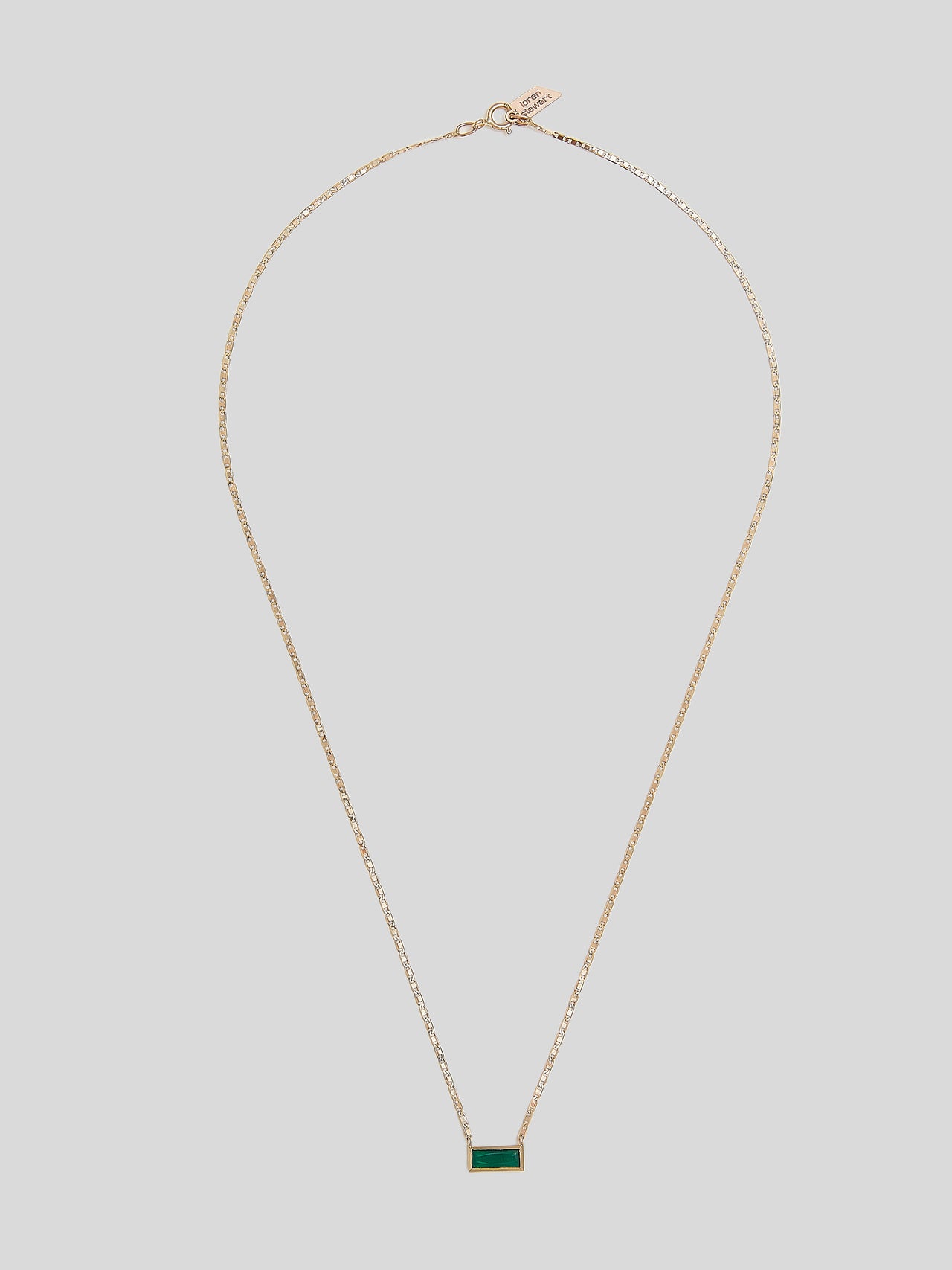 Product image of 10kt yellow gold thin chain necklace with thin green rectangular gemstone on white background. 