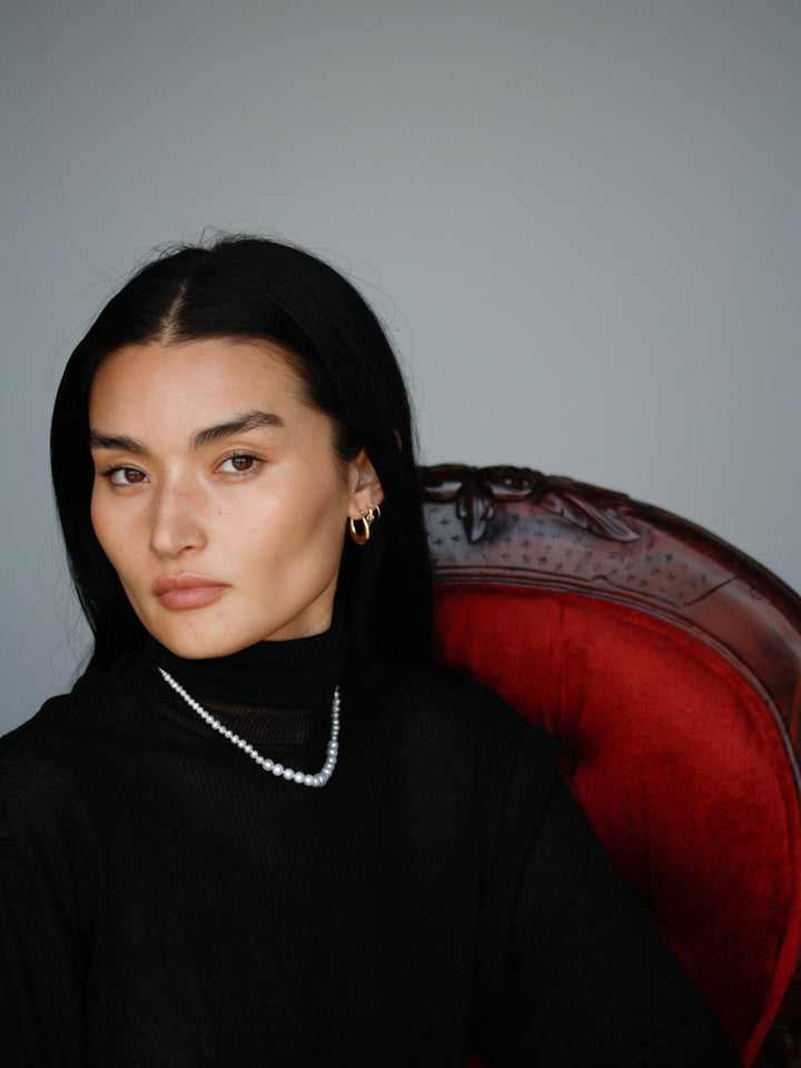 Dome Hammock Hoops pictured on model. Red chair and grey background. 