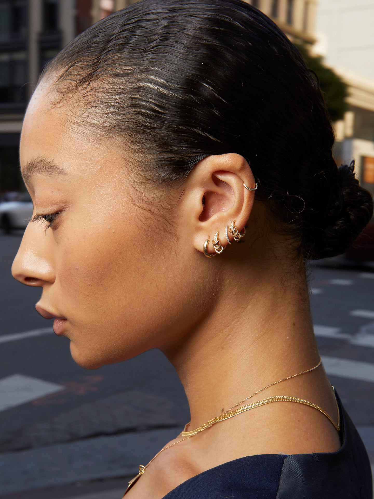 14kt Yellow Gold Anelli Huggies pictured in models first piercing. 