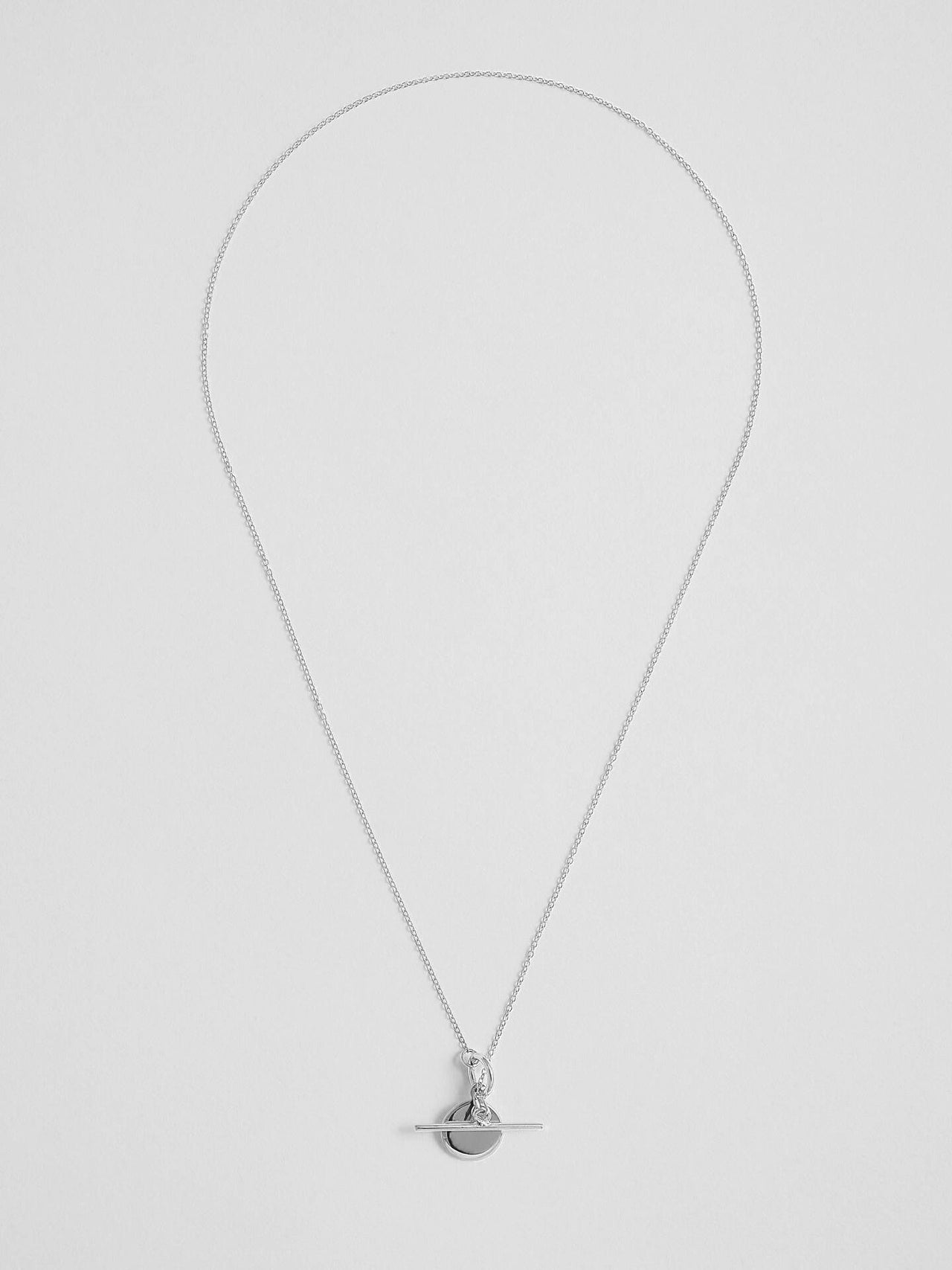 Sterling Silver Mini Disk and Toggle Necklace pictured on light grey background. 