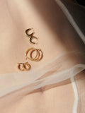 14kt Yellow Gold Dome Hammock Hoops pictured on stomach, silk material.
