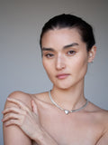 Suki Pearl Necklace pictured on model. Light grey background. 