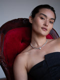 Suki Pearl Necklace pictured on model sitting in red velvet chain.