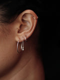 Sterling Silver Ultralight Infinity Hoops pictured on model in third piercing. 