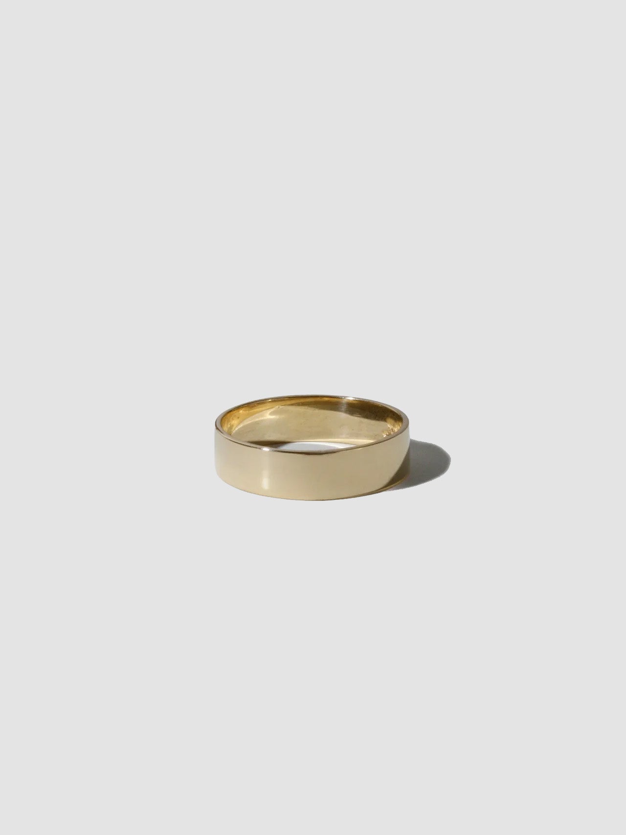 Gold ring on a light gray background