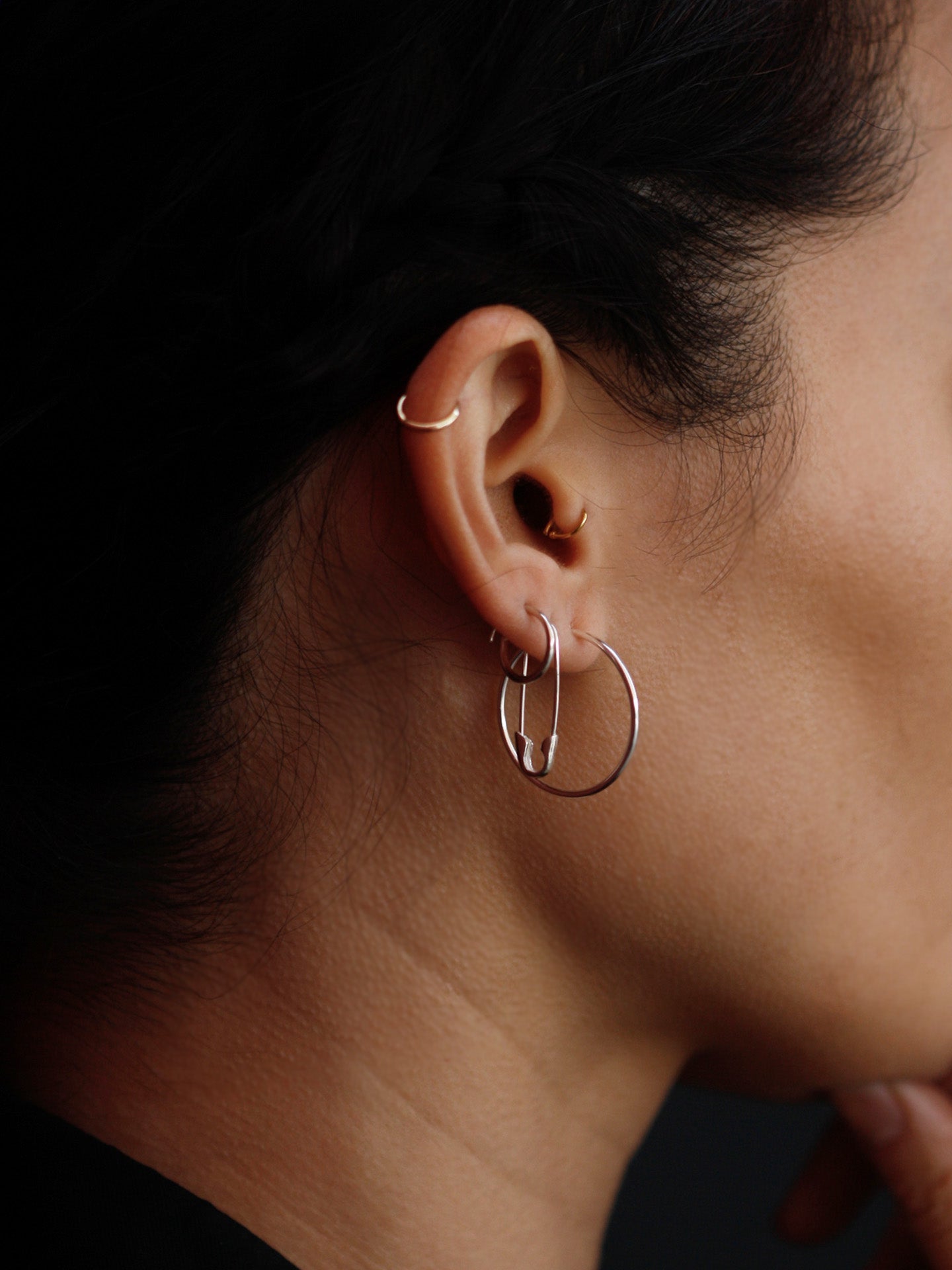 Riley hoops pictured in models first piercing. Black background. 