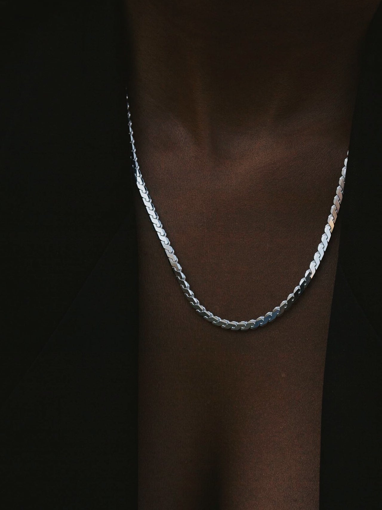 Serpentine Chain pictured in Sterling Silver on models neck. 