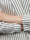 14kt Yellow Gold Eastsider ID Bracelet pictured on models wrist along with the Demi Herringbone Bracelet. 