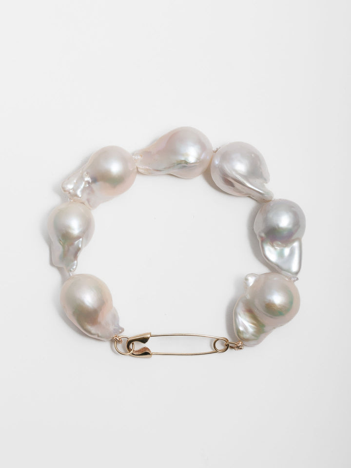 14kt Yellow Gold Safety Pin Baroque Pearl Bracelet pictured on light grey background.