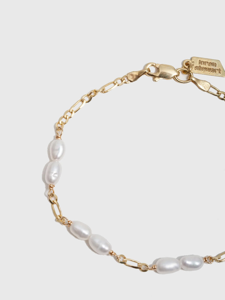 14kt Yellow Gold Solid Petite Figaro Pearl Bracelet pictured on light grey background.