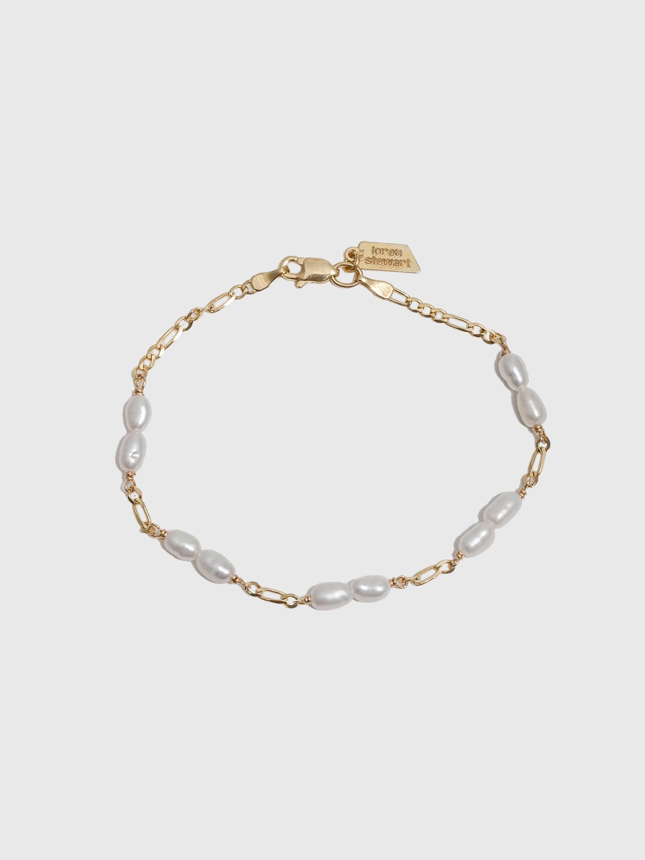 14kt Yellow Gold Solid Petite Figaro Pearl Bracelet pictured on light grey background.