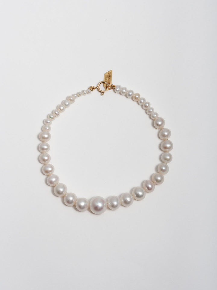 14kt Yellow Gold Graduating Pearl Bracelet pictured on light grey background.  
