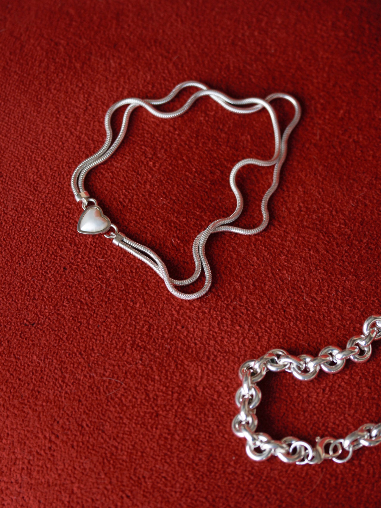 Suki Pearl Necklace pictured laid on red textured background. Flat lay image. 