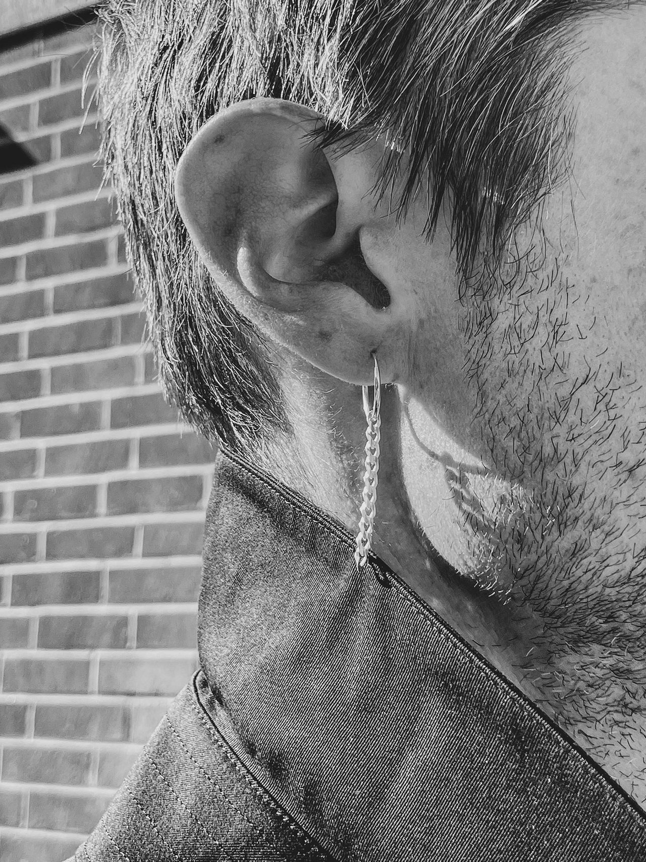 Sterling Silver Chain Huggie pictured on models ear.