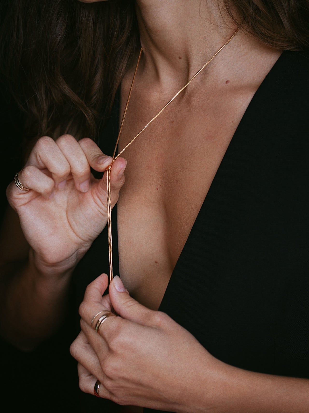 Close up shot of model wearing the Vermeil Bolo Pendant Necklace. Showing how the necklace is adjustable. 
