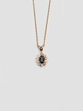 14kt Yellow Gold Diamond Sapphire Halo Necklace shot on white background.