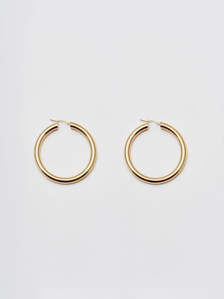 Product Shot of the Tru Hoops in Vermeil gold (Vermeil Hoops 49.5mm diameter 5mm thick) Background: Grey backdrop
