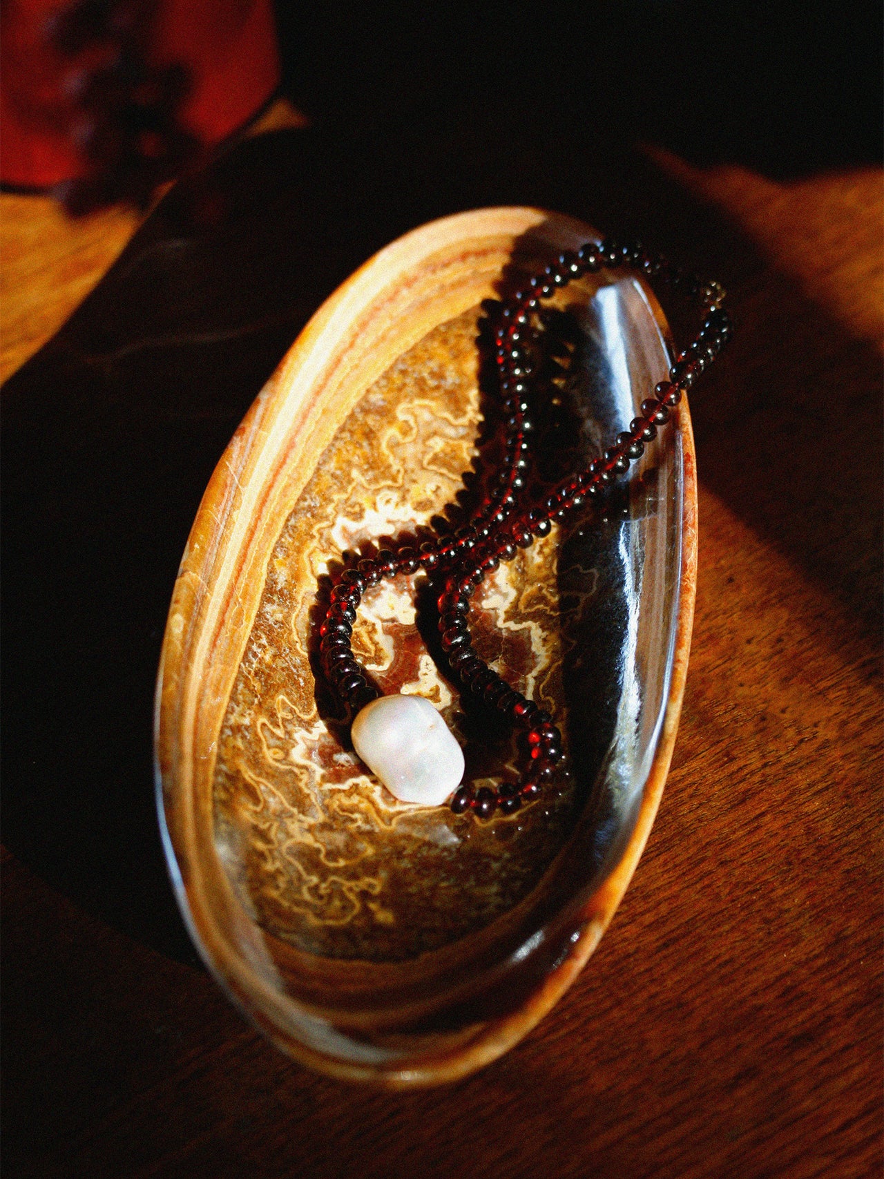 Close-up of a beaded necklace on a decorative stone surface