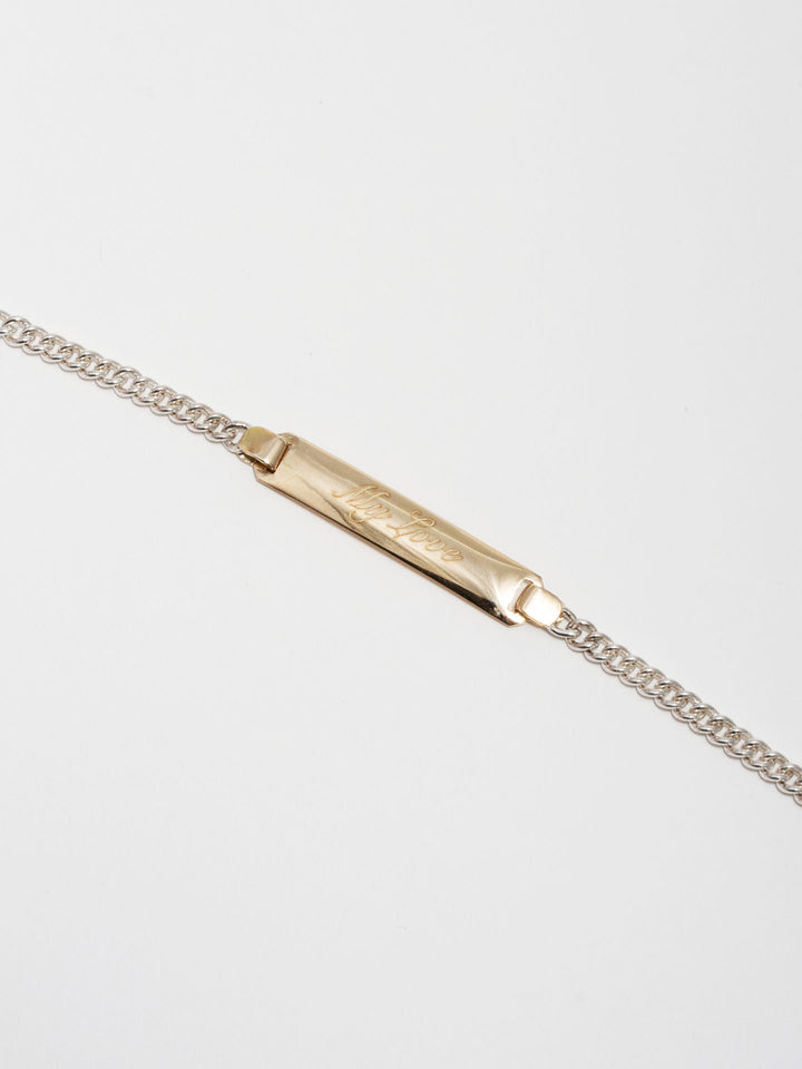 14kt Yellow Gold and Sterling Silver ID Bracelet engraved with 'My Love' in Script Font. Light grey background. 