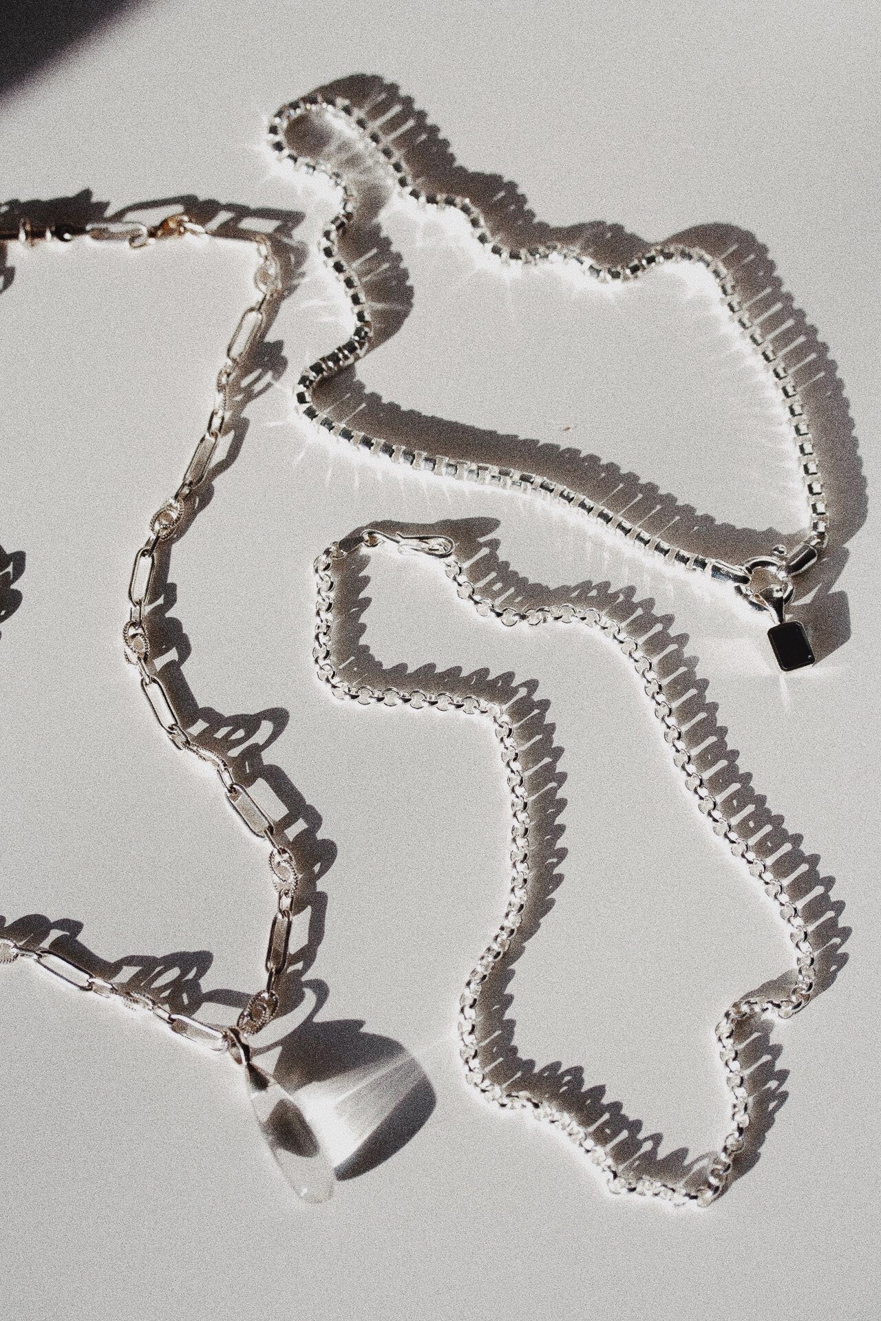 Sterling Silver Rolo Chain Necklace pictured along side the Stone Teardrop Necklace and the Cube Chain Choker with Blue London Medallion Pendant. 