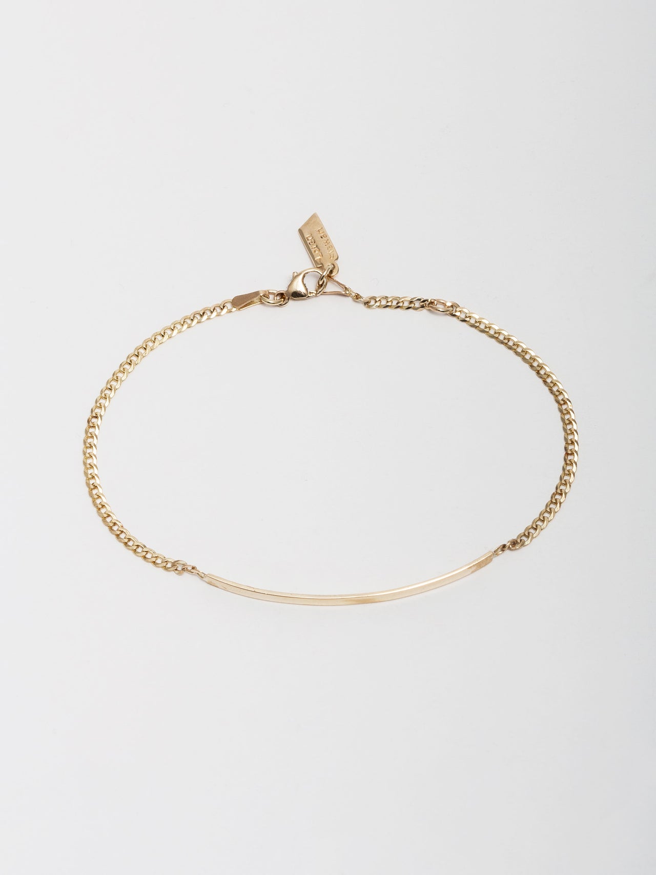 14kt Yellow Gold Eastsider ID Bracelet pictured on light grey background from above.