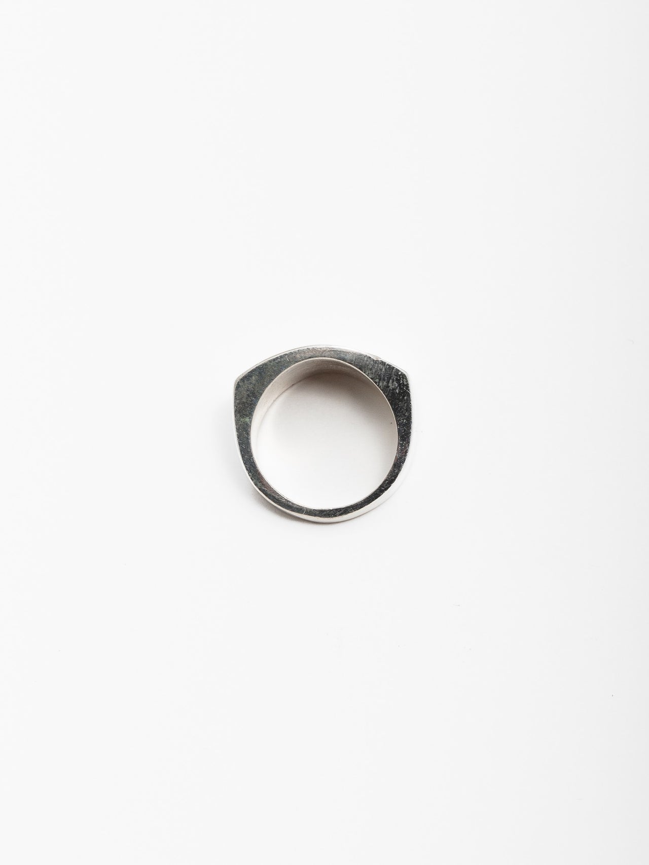 Sterling Silver ID Ring pictured from above. Overview of band. Light grey background.