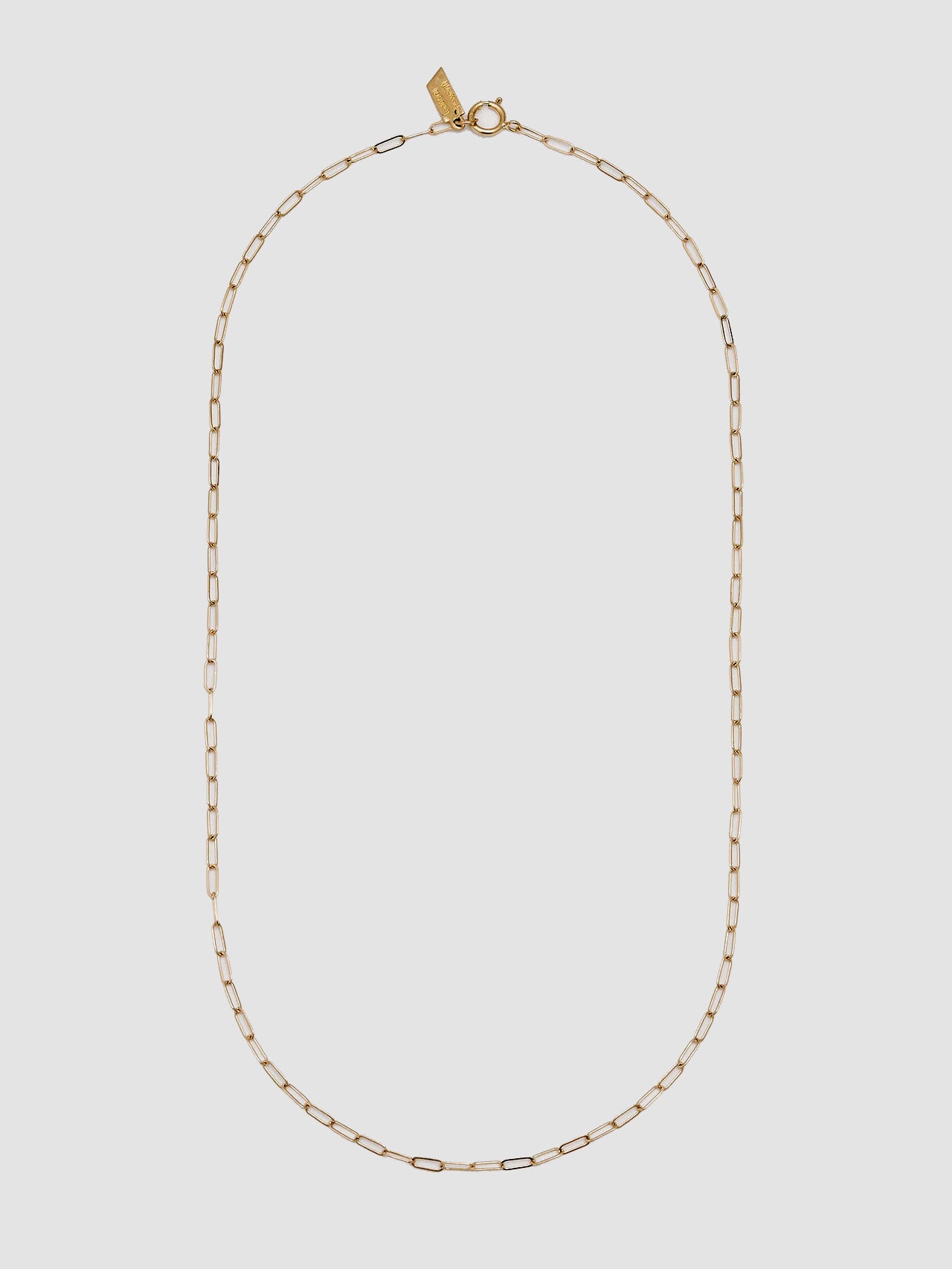 Gold chain necklace on a light gray background