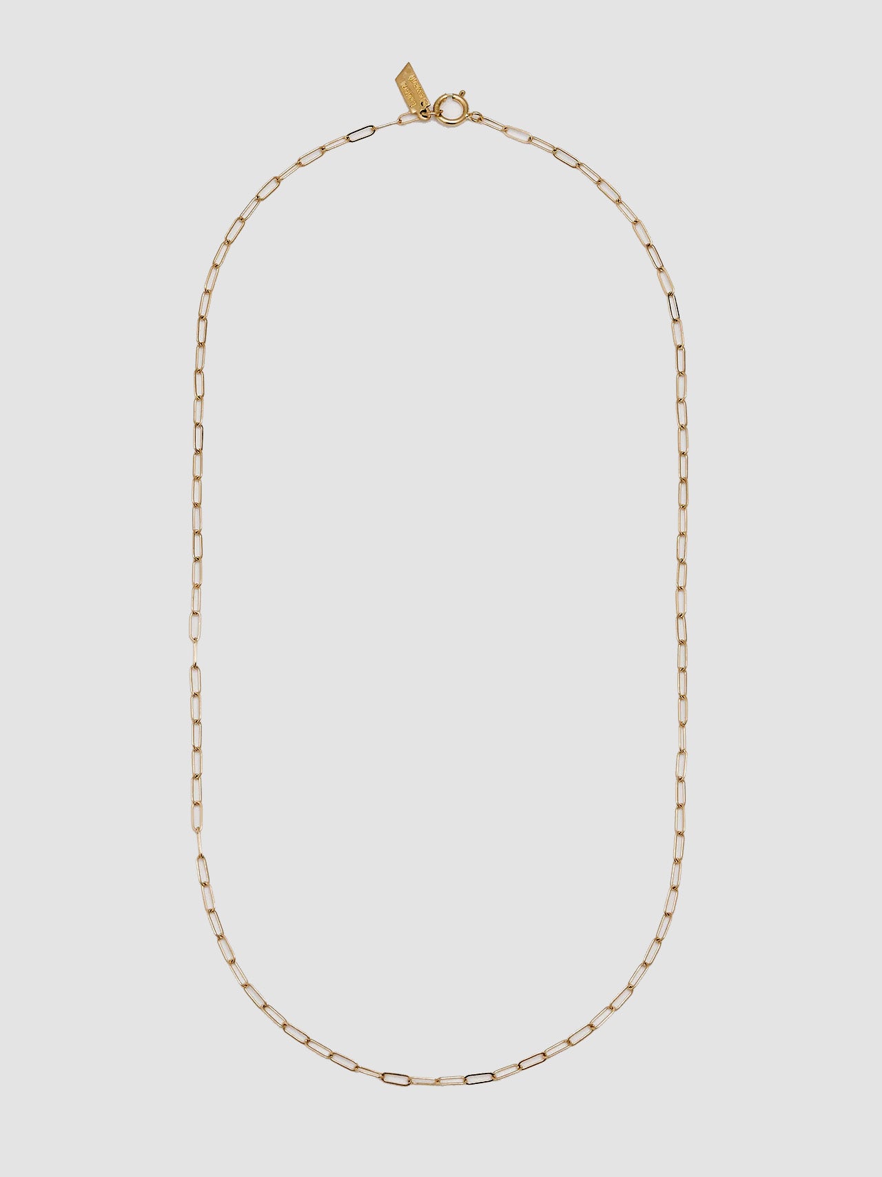 Gold chain necklace on a light gray background