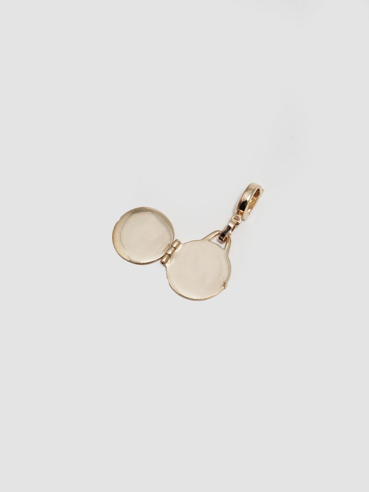 14Kt Yellow Gold Locket Pendant pictured lying open on light grey background. 