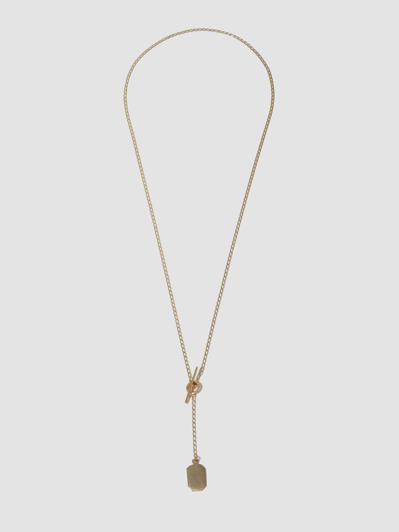 A 14kt yellow gold octagonal ID toggle lariat necklace with a sculptural ID tag and a bold toggle closure. The necklace is designed for layering and has a lariat drop.