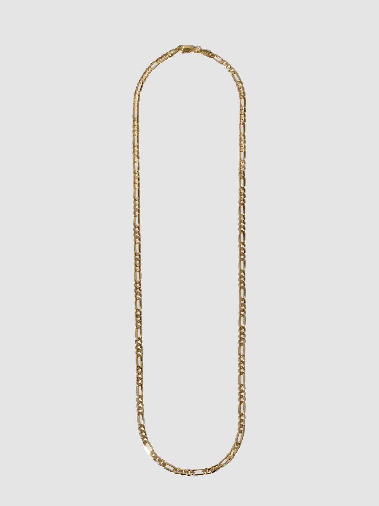 14kt Yellow Gold Solid Figaro Chain Necklace pictured on light grey background.