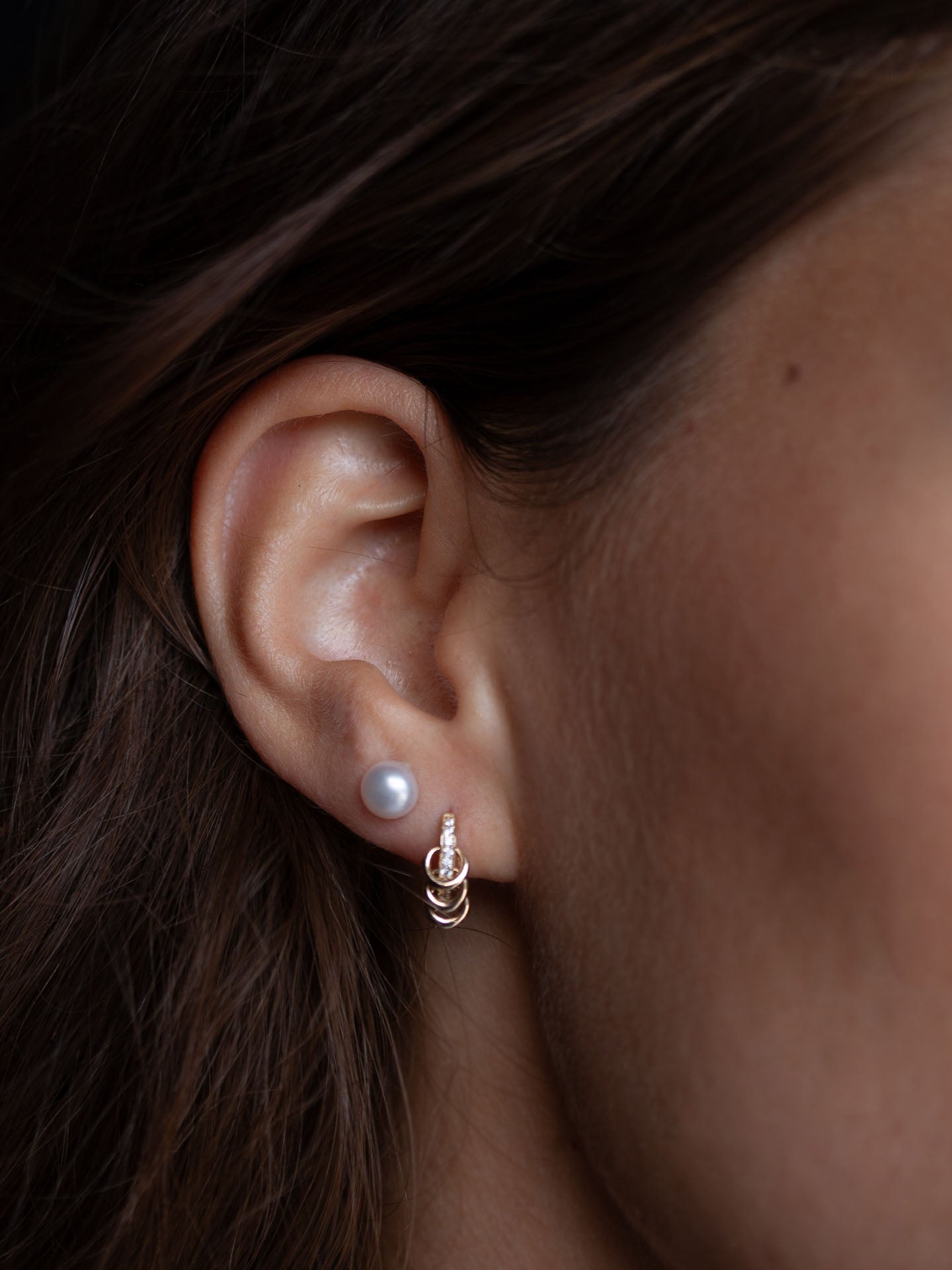 On model image of pearl studs on models ear.