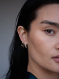 Mini Triangle Safety Pin Earring in Yellow Gold pictured in models second piercing. 