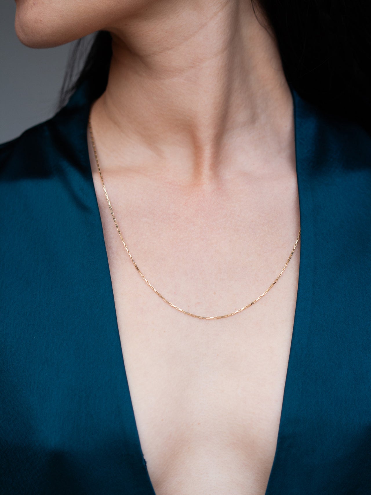 14kt Yellow Gold Elongated Box Chain pictured on model wearing 20" length. 