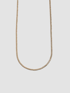 Gold chain necklace on a light gray background