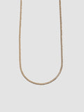 Gold chain necklace on a light gray background