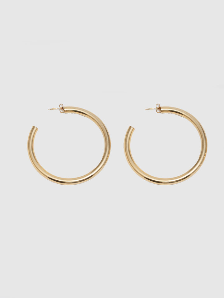 14kt Yellow Gold Tube Hoops pictured on light grey background.
