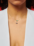 10kt Yellow Gold Gemstone Valentino Chain Necklace pictured on model in both green and blue. Red background.