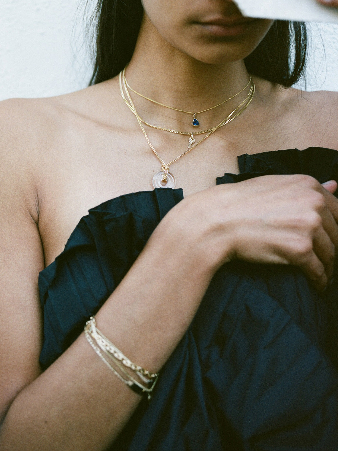 14Kt Yellow Gold Square Wheat Chain & Quartz Pendant Necklace pictured on models neck. Chain knotted through clear quartz donut. 