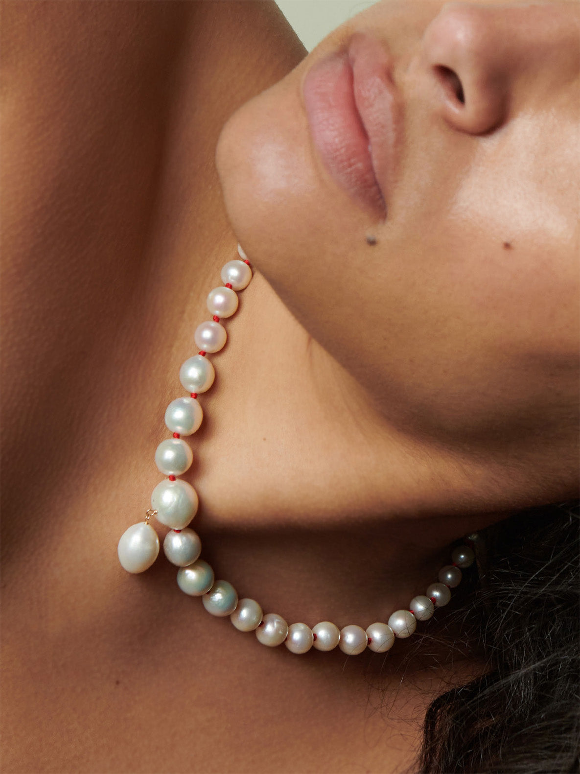 Boujee 14kt Yellow Gold Pearl Necklace pictured on model. Red thread.