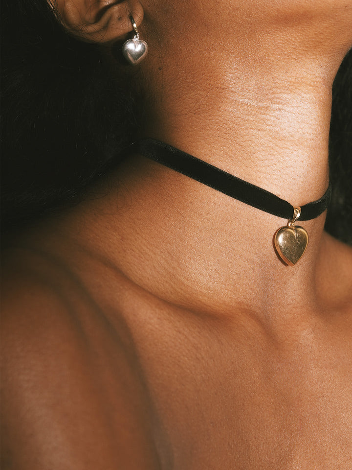 14kt Yellow Gold Click-On Huggies pictured on model. Black background.