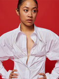 Sterling Silver Body Chain pictured on model worn over white button down. Red background.