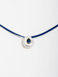 14kt Yellow Gold Evil Eye Pearl Necklace pictured close up of pearl pendant on light grey background. 